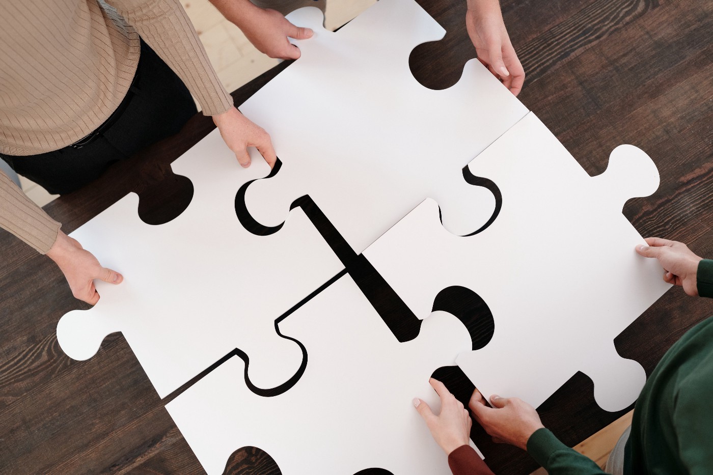 People fit together four large puzzle pieces.