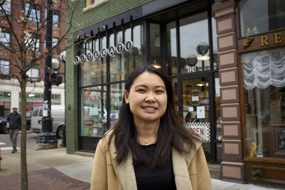 An Doan stands in front of a store facade on a street