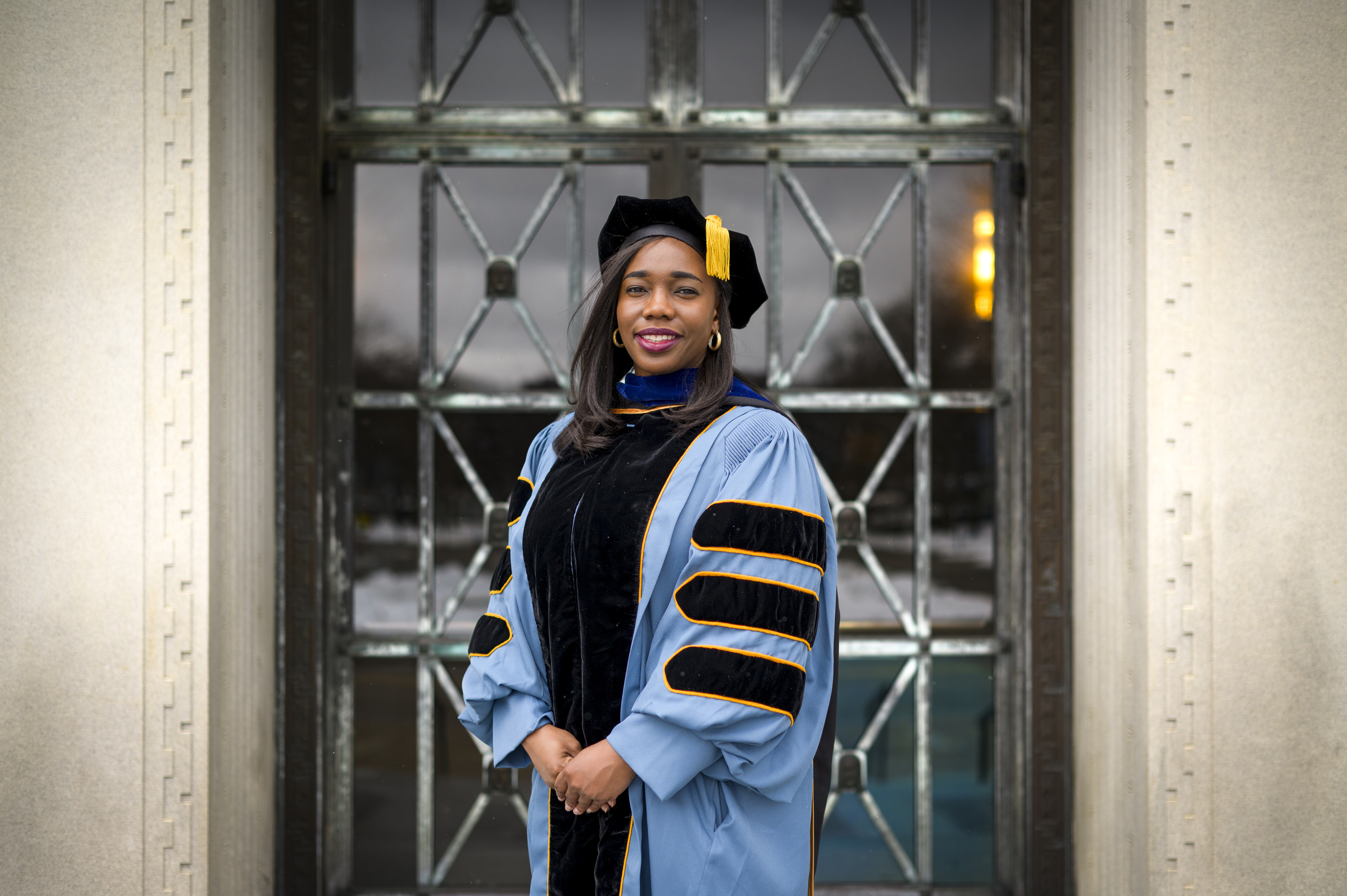 A student wearing full graduation regalia for a doctoral student.