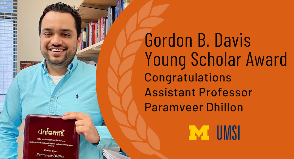 Paramveer Dhillon holding a plaque in his office. "Congratulations Assistant Professor Paramveer Dhillon, 2021 Gordon B. Davis Young Scholar Award recipient"