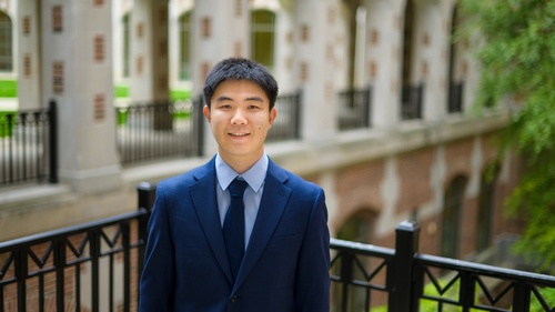 A photo of Jiaxin Pei standing in the courtyard outside of North Quad. 