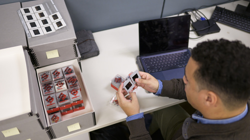A student looking through boxes of 35mm slides at a desk