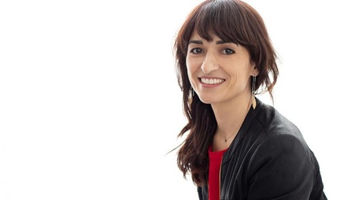 Headshot of Sandra Gonzalez smiling in front of a plain white wall