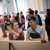 A student and a professor discussing a research poster