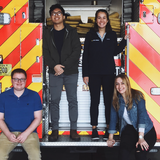 UMSI students standing on a fire truck