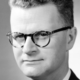 A black and white headshot of Erik J Spicer