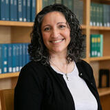 A headshot of Nikki Roda in front of library shelves