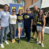 The UMSI Development and Alumni Relations team posing together. They are all wearing University of Michigan apparel.