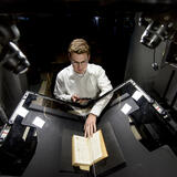 A person scanning a book with a large scanner
