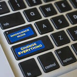 A laptop keyboard with two stickers that say MAD science mode and Change Everything.