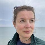 A headshot of Linda Huber in front of a body of water.