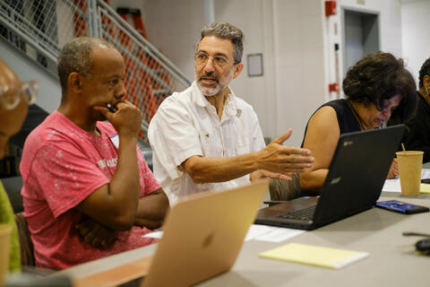 students looking at laptops and discussing