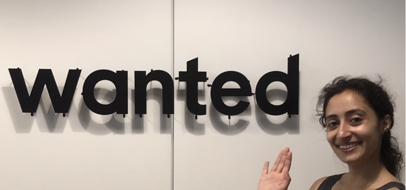 Salma Siddiqui next to a sign that says wanted
