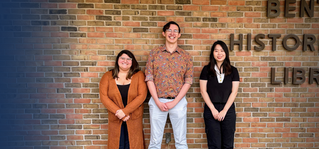 Three students standing in front of a sign that says Bentley Historical Library