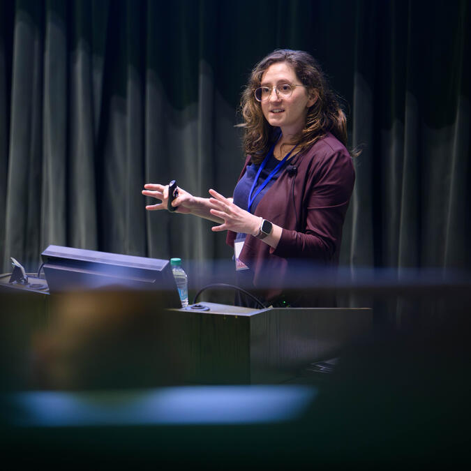 Abigail Jacobs gestures while speaking at a podium