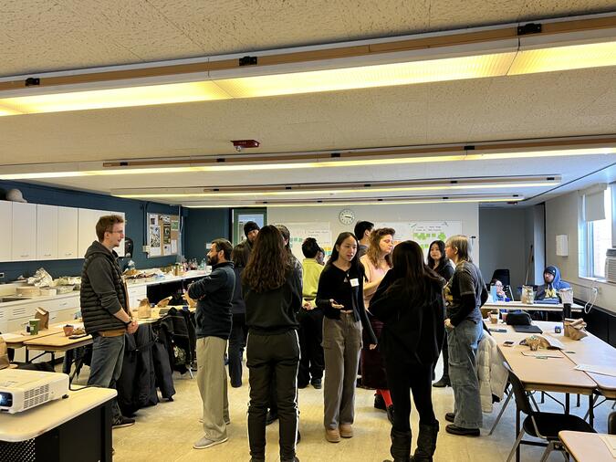 A group of people talking together in a classroom.