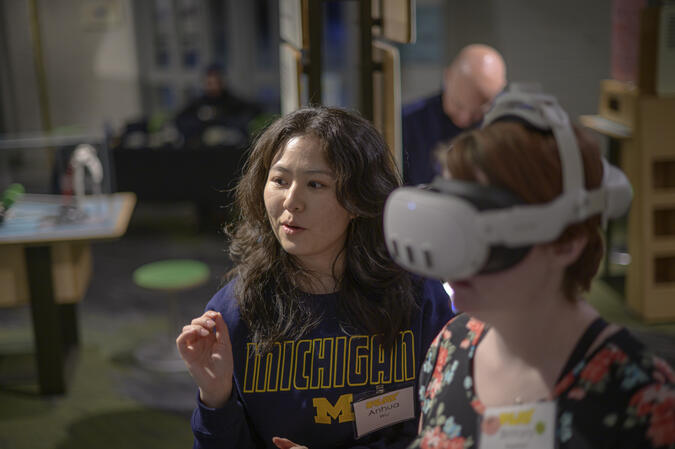 Anhua Wu gestures while standing beside a person in an MR headset