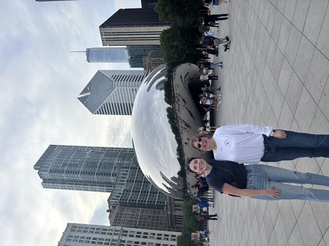 Katie Clementi and another person posing in front of the Bean in Chicago.