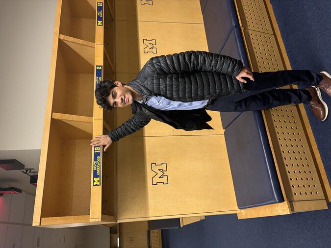 Shiv Bhatia touching a cubby that is labeled "Bryce Underwood 19"