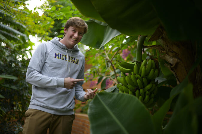 A student points to a plant at the U-M Matthaei Botanical Gardens.
