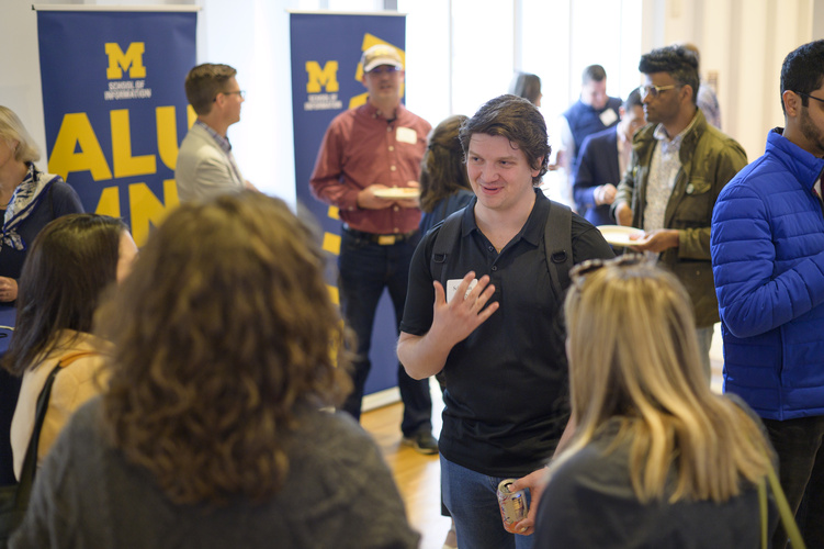 Students mingle in space 2435, a large event space
