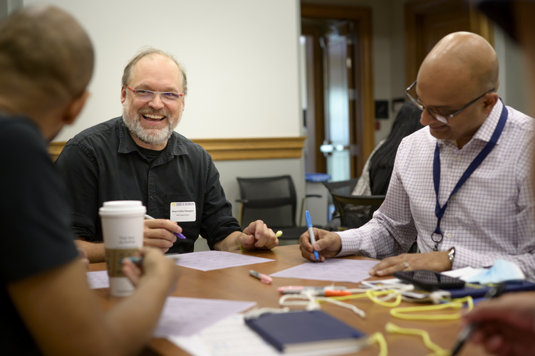 Students and faculty sit at a table