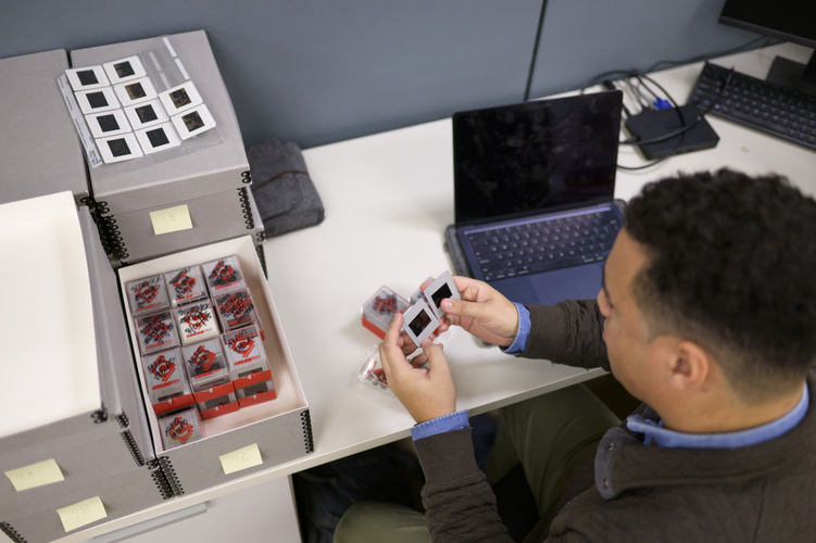 Jack Schmitt holds two photographic slides he is processing 