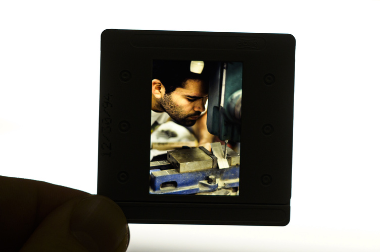 A photographic slide from the Chadwick collection is pictured on a white background. It is a close-up shot of an employee working in an industrial studio.