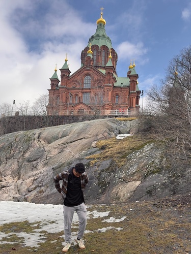 David Diokno poses in front of a cathedral in Finland, with snow on the ground.