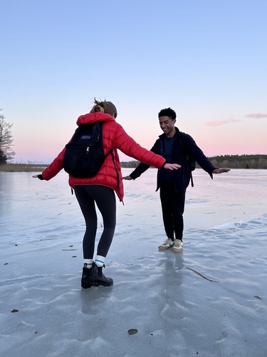 Two people balance on a frozen lake in Sweden
