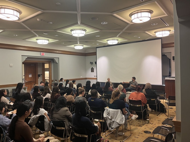 Students sit in North Quad and listen as a University of Michigan alumnus discusses his career journey and takes questions about his experiences.