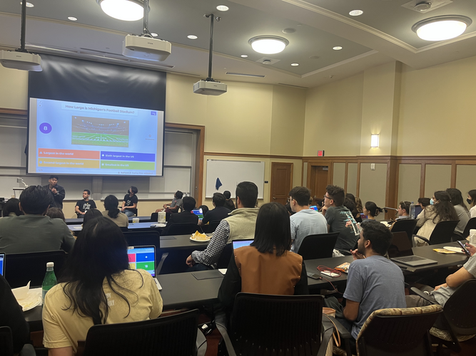 Representatives from Roblox engage students in a large classroom with a University of Michigan-themed trivia game before spotlighting their new features through a product demo.