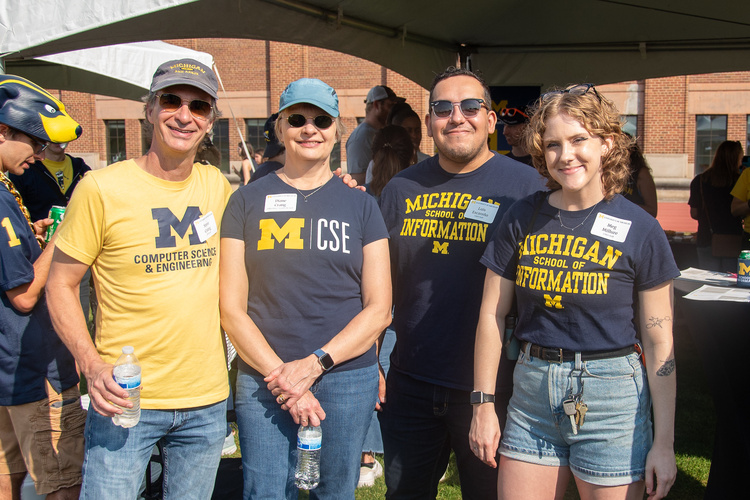 Staff from UMSI and U-M CSE pose for a photo together wearing school T-shirts