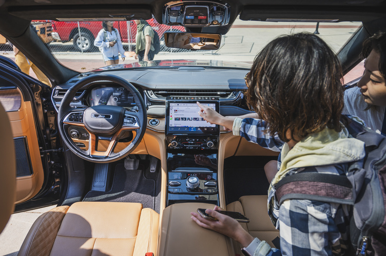 An interior view of a vehicle as two students interact with the in-vehicle interface
