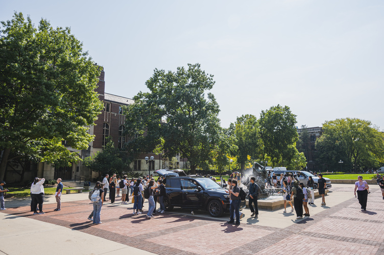 A crowd of students gathered around Stellantis vehicles on the Ingalls Mall