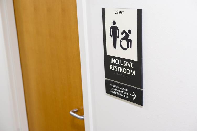 A view of a restroom door with a plaque to the right that says "inclusive restroom"