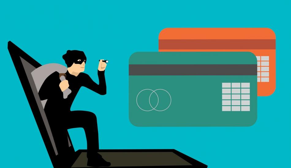 Illustrated graphic shows burglar in mask with sack emerging from laptop screen, approaching two credit cards.