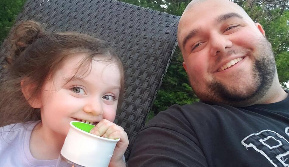Matthew Wiese smiles next to his child