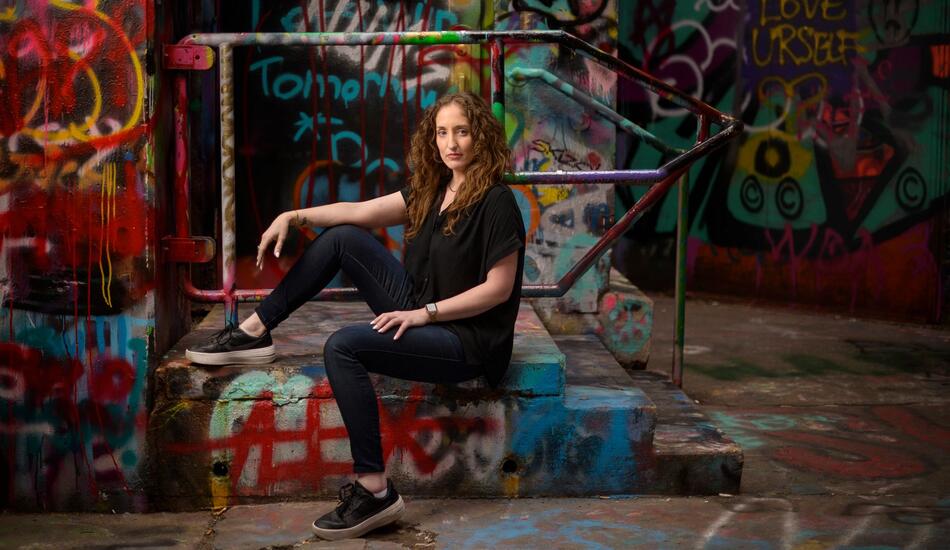 Michaelanne Thomas pictured in an alley with colorful graffiti