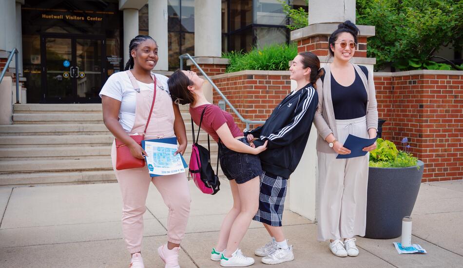 Community college students touring the U-M campus make the Michigan “M” by posing as different parts of the letter in front of the Huetwell Visitors Center.