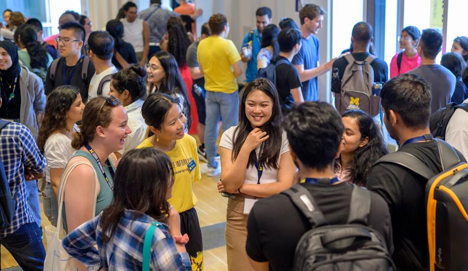 Students mingle in space 2435, a large event space