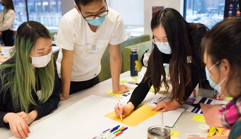 Students work in groups at tables in the UMSI engagement center.