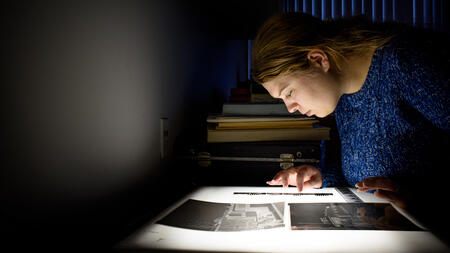Joanna Lincoln looking at photos on a lightbox
