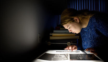 Joanna Lincoln looking at photos on a lightbox