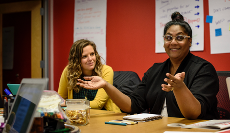 Two people having a discussion at a conference table