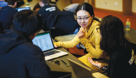 A group of three students working together in a classroom