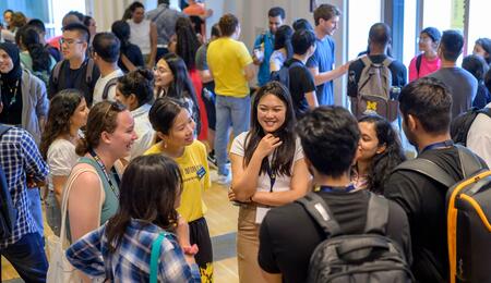 Students mingle in space 2435, a large event space