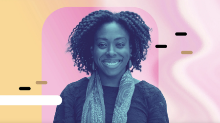 Robin Brewer smiling and wearing a sweater and scarf. 