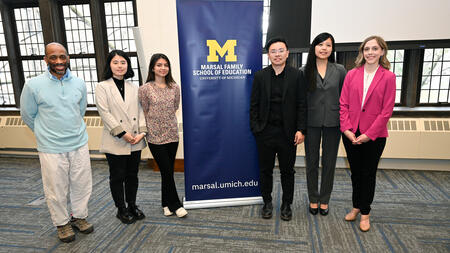 A photo of the Learning Lever Prize winners posing beside a Marsal Family School of Education banner