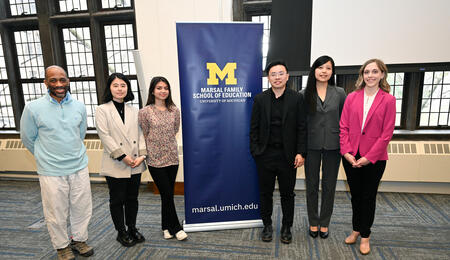 A photo of the Learning Lever Prize winners posing beside a Marsal Family School of Education banner